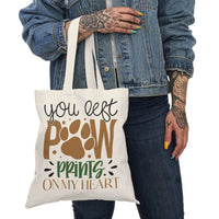 Printify eco-friendly paw print tote bag featuring You Left Paw Prints On My Heart design held by person
