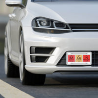 White car front view featuring Printify novelty license plate with periodic table elements design