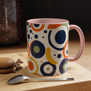 Printify pop art coffee mug with colorful abstract circle patterns and pink handle on wooden table