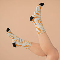Printify recycled poly socks with orange and cream swirl pattern and black heel and toe on raised feet