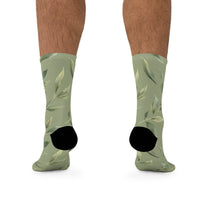 Printify green leaf pattern recycled poly socks with black heel and toe on model legs