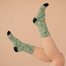 Printify recycled poly socks with green leafy pattern and black heel and toe on feet