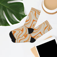 Printify recycled poly socks with orange swirl pattern and black heels and toes laid flat on white surface