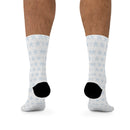 Printify sustainable recycled poly socks with white background and blue snowflake pattern on model feet