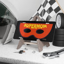 Printify Supermom vanity plate with red mask design displayed on wooden stand among car accessories