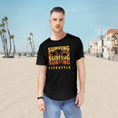 Printify black eco friendly surfing t shirt with orange surfing lifestyle graphic worn on beach