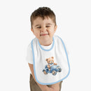 Toddler wearing Printify sustainable baby bib with blue trim and teddy bear driving a car design