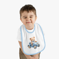 Toddler wearing Printify sustainable baby bib with blue trim and teddy bear driving a car design