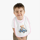 Child wearing Printify sustainable baby bib featuring a teddy bear driving a blue car with pink trim