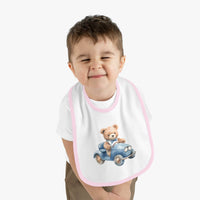 Child wearing Printify sustainable baby bib featuring a teddy bear driving a blue car with pink trim