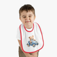 Toddler wearing a sustainable baby bib with red trim and teddy bear driving a blue car design