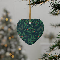 Heart-shaped sustainable ceramic holiday decorations with green leaves and red berries hanging on Christmas tree