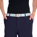 Close-up of person wearing a light gray sustainable fashion belt with metal buckle and navy pants