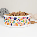 Sustainable pet bowl with a fancy design featuring colorful abstract patterns and filled with dog treats