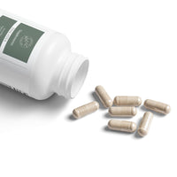 White bottle of Printify Thalassa Sea Moss Capsules with several capsules spilled on white surface