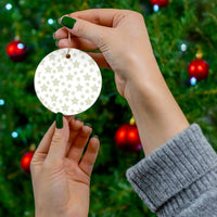 Printify twinkling stars holiday decoration round ornament held near Christmas tree with red baubles