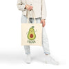 Printify eco-friendly cotton tote bag with a smiling avocado and vegan text held by a person