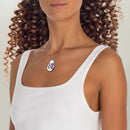Printify eco-friendly love necklace with colorful LOVE pendant worn on a silver chain by a woman in white top